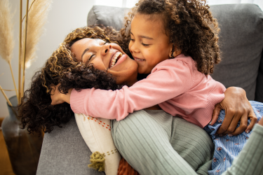 Parent qui donne de l’attention positive à son enfant en lui faisant un câlin