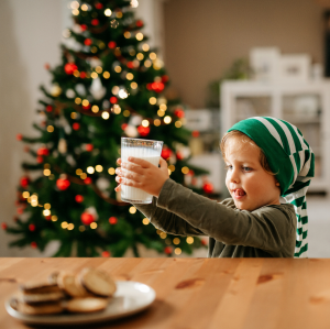 Enfant qui prépare le lait et les biscuits pour le père Noël
