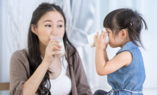 Une mère et sa fille boivent du lait.
