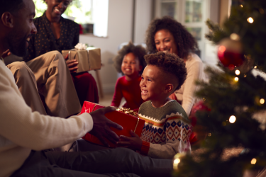 Enfant qui donne un cadeau de Noël à son parent