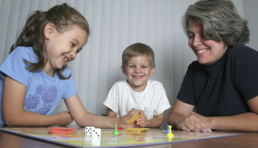 Parent qui joue à un jeu de société avec ses enfants