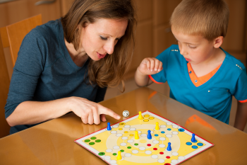 Une mère et son jeune garçon jouent à un jeu de société. 