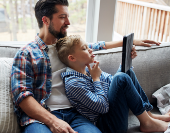 Père et son enfant qui regardent un écran