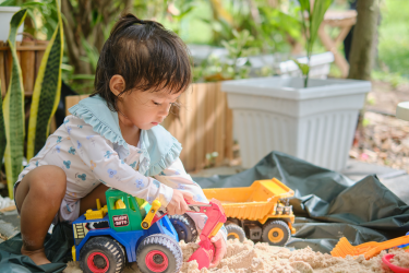 Petite fille qui joue avec des camions Petite fille qui joue avec des camions