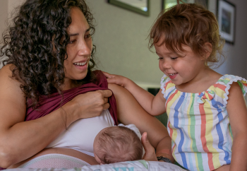 Mère qui s’occupe de son nouveau-né et de son enfant plus vieux