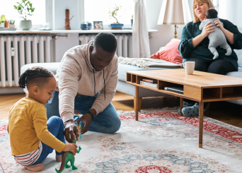 Papa qui joue avec son enfant pendant que maman s’occupe du bébé. Papa qui joue avec son enfant pendant que maman s’occupe du bébé.