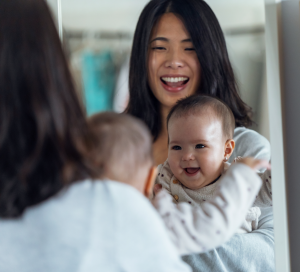 Parent qui joue avec son bébé devant un miroir