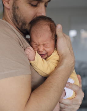 Père qui essaie de soulager les coliques de son bébé